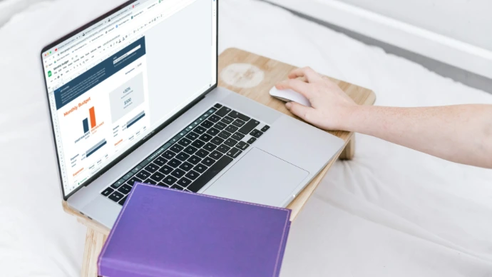 a person using a laptop computer on a bed